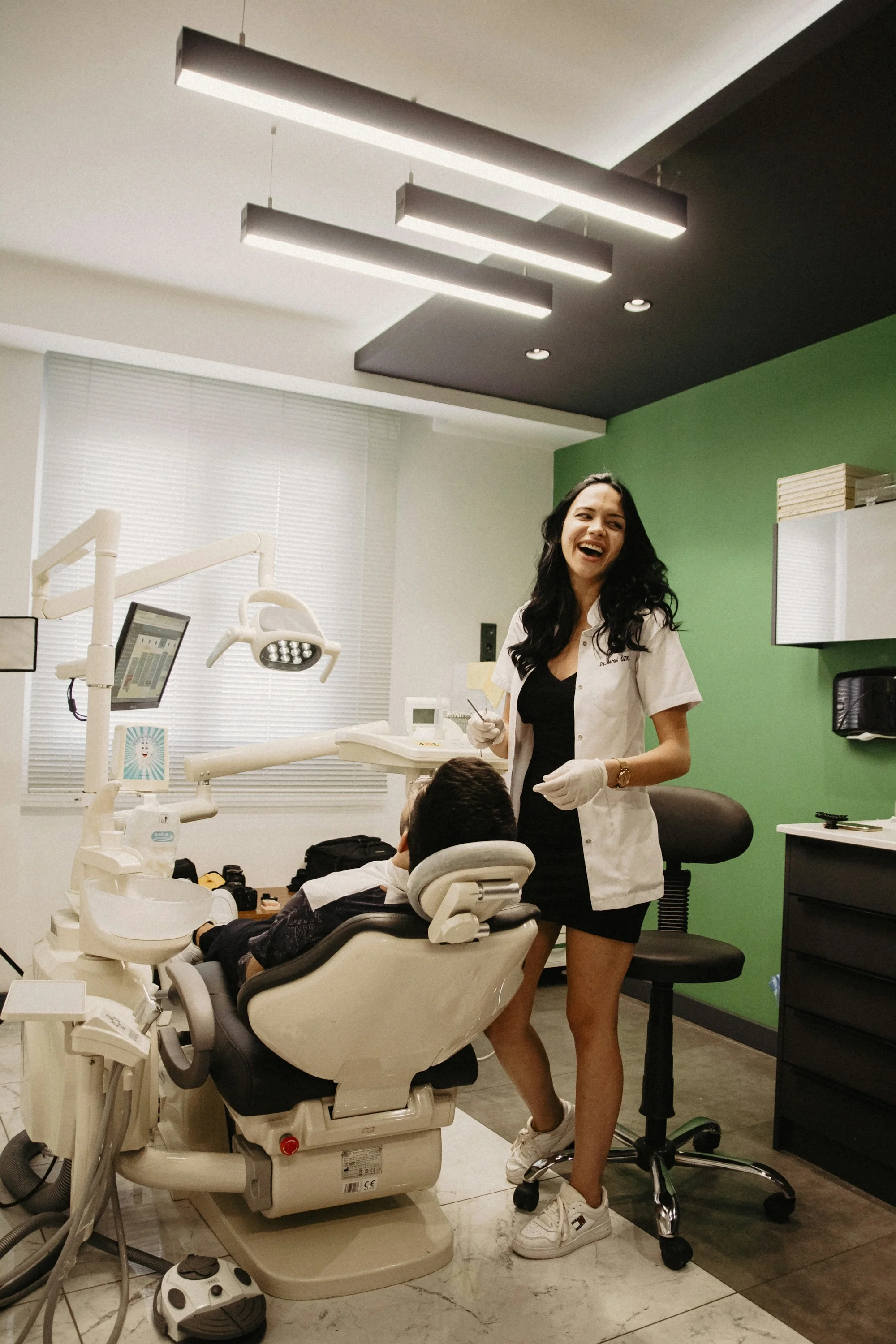 Dentista sonriente atendiendo a un paciente en su clínica